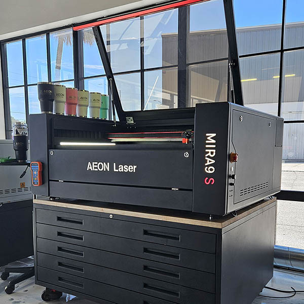 Product specialist and person looking at an Aeon laser together in the 日文乱码 showroom