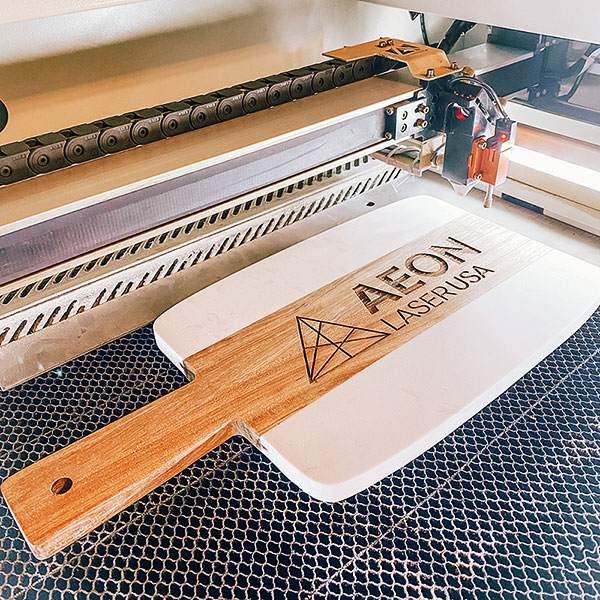 Custom wood and marble cutting board with 男欢女爱久石 logo engraved on it