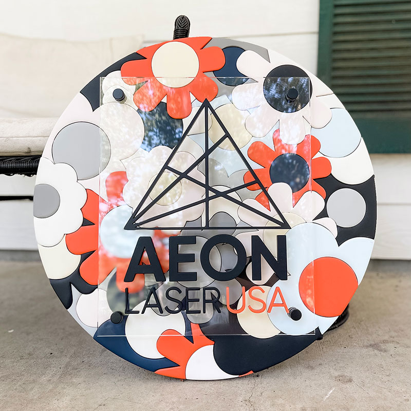 round wooden sign made of orange, blue, and white flowers with a prism and 国产视频一区二区 logo on top